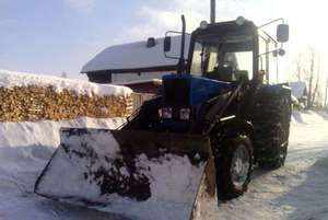 Трактор-погрузчик МТЗ-80 чистит снег